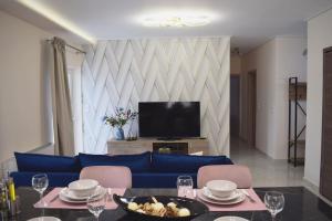 a living room with a blue couch and a tv at Seafront Luxury Apartment in Amfilochia