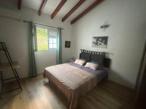 a bedroom with a bed and a large window at Villa cosy, piscine et plage. in Les Trois-Îlets