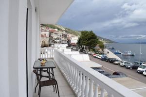 a balcony with a table and a view of a street at Seafront Luxury Apartment in Amfilochía