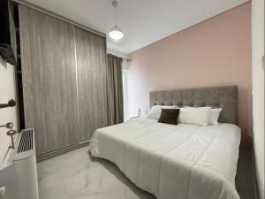 a bedroom with a large white bed and a window at Seafront Luxury Apartment in Amfilochia