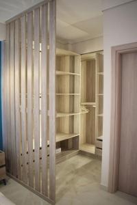 a closet with wooden shelves in a room at Seafront Luxury Apartment in Amfilochía