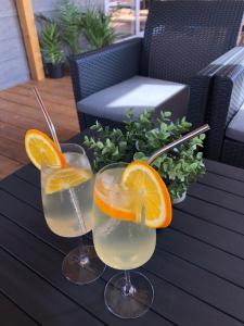due bicchieri di limonata e una fetta d'arancia su un tavolo di Villa Family Grand de Luxe Mobilhome a Selce