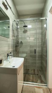 uma casa de banho com um chuveiro, um lavatório e um WC. em Apartmani Toki Balkana em Mrkonjic Grad