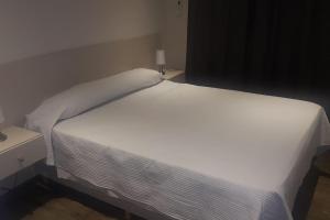 uma grande cama branca num pequeno quarto em Loft de lujo en el corazón de Mendoza con Parking em Mendoza