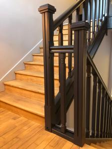 a staircase with black railings and wood floors at Hôtel de la Glane in Oradour-sur-Glane