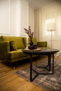 a living room with a green couch and a coffee table at Room21 FREE GARAGE in Novi Sad