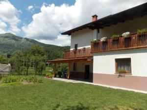 ein Haus mit einem Balkon mit Blumen darauf in der Unterkunft Apartment and Room Natasa in Kobarid