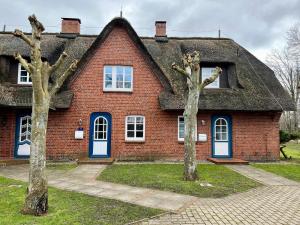 a red brick house with two trees in front of it at Haus Friesenfeuer in Nieblum
