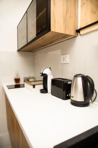 a kitchen counter with a toaster and a tea kettle at Room21 FREE GARAGE in Novi Sad