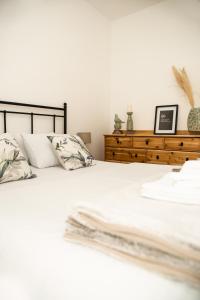 a bedroom with a white bed with pillows and a dresser at Room21 FREE GARAGE in Novi Sad