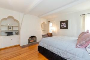 une chambre avec un lit et une cheminée dans l'établissement Renovated Spanish 3BD 2BA near Beverly Hills, à Los Angeles