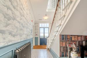 a hallway with a staircase and a book shelf at Carlton Manor in Hull