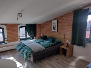 um quarto com uma cama e uma parede de tijolos em 13 Starówka apartament Miodova em Toruń