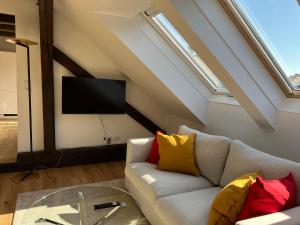 ein Wohnzimmer mit einem Sofa und einem Flachbild-TV in der Unterkunft Modern City Apartment in Graz