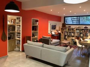 sala de estar con sofá blanco y pared roja en Le Beau Repaire 1 à 3 chambres étage indépendant en Angers