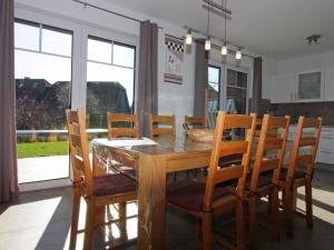 een eetkamer met een houten tafel en stoelen bij Holiday home, Friedrichskoog-Spitze in Friedrichskoog-Spitz