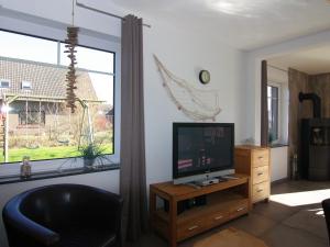 een woonkamer met een televisie en een raam bij Holiday home, Friedrichskoog-Spitze in Friedrichskoog-Spitz
