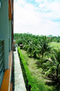 uma vista a partir da varanda de uma casa com palmeiras em 777 Beach Condo Phuket em Praia de Mai Khao