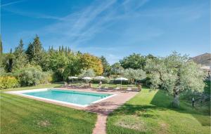 una piscina en un patio con sillas y sombrillas en Casa Roseto, en San Donato in Poggio