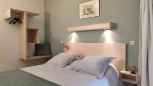 un lit avec des draps blancs et des oreillers dans une chambre dans l'établissement Le Clos Marie, à Ciney