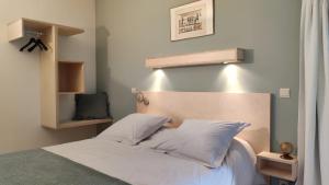 Una cama con sábanas blancas y almohadas en un dormitorio en Le Clos Marie, en Ciney