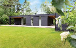 una casa negra con un patio verde en 5 Bedroom Nice Home In Rrvig, en Rørvig