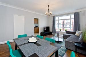 a dining room and living room with a table and chairs at Baker Street Apartments in London