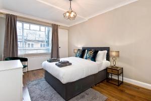 a bedroom with a large bed and a window at Baker Street Apartments in London