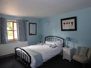 a bedroom with a bed and a chair and a window at The Catkins, Grove flock farm in Diss