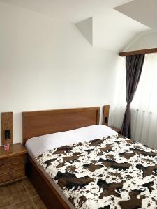 um quarto com uma cama com um cobertor preto e branco em Apartments & Rooms Brijest em Plav