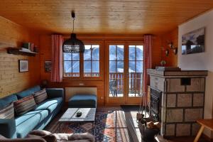 a living room with a blue couch and a fireplace at Am Bühl OG in Bettmeralp