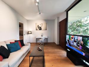 a living room with a couch and a flat screen tv at Vivo Apartments in Athens