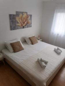 een slaapkamer met een groot wit bed en 2 handdoeken bij Holiday home Filip i Petra in Donji Proložac