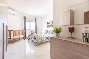ein weißes Schlafzimmer mit einem Bett und einem Balkon in der Unterkunft H2 -Modern and Spacious 3 Bedroom Apartment in San Ġwann