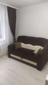 ein schwarzes Sofa im Wohnzimmer mit Fenster in der Unterkunft Квартира студия in Chişinău