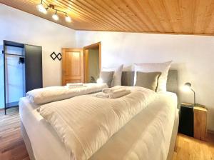 Duas grandes camas brancas num quarto em Ferienhaus Weißachdamm am Tegernsee em Rottach-Egern