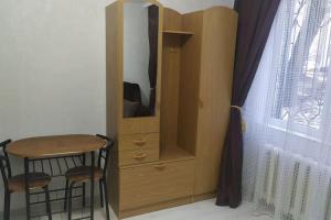 einem Holzschrank mit einem Stuhl neben einem Fenster in der Unterkunft Квартира студия in Chişinău