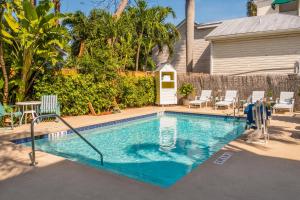 a swimming pool with chairs and a house at La Pensione Inn - Adult Exclusive in Key West