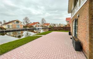 a brick building with a brick walkway next to a river at It Soal Waterpark-waterlelie in Workum