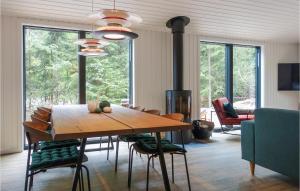 a dining room with a wooden table and chairs at Lovely Home In Nexø With Kitchen in Neksø