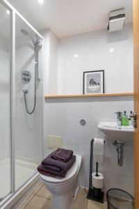 a bathroom with a shower and a toilet and a sink at City View - A Stunning 2 Bed Apartment in Glasgow