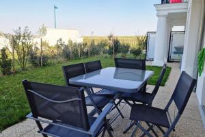 a table and four chairs sitting around a patio at Appartement Chic Gold - 5min Disneyland in Serris