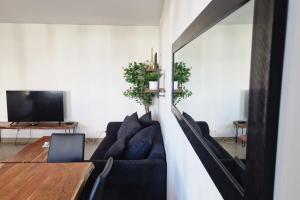 a living room with a couch and a table at Appartement Chic Gold - 5min Disneyland in Serris