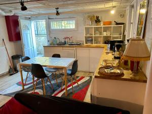 a kitchen with a table and chairs in a room at Rez de Jardin intégral Disney & Paris & Sites Olympiques in Chelles