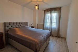 a bedroom with a large bed and a window at Appartement Chic Gold - 5min Disneyland in Serris