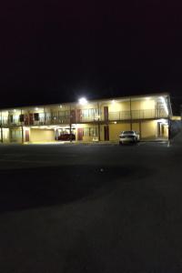 a building with a car parked in front of it at night at Lotus by Hotel Inn - Hot Springs in Hot Springs