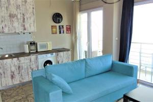 a blue couch in a living room with a microwave at Perea sea view in Perea