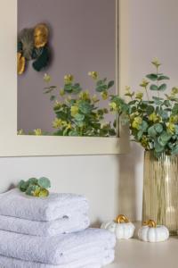 a stack of towels on a counter with a vase of flowers at Anna Studio in Amoudara Herakliou