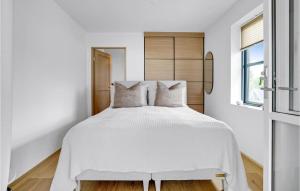 a bedroom with a white bed with a wooden headboard at Awesome Apartment In Kerteminde With House Sea View in Kerteminde