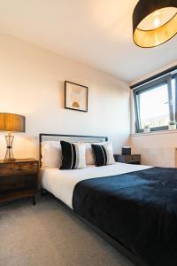 a bedroom with a large bed and a window at City View - A Stunning 2 Bed Apartment in Glasgow